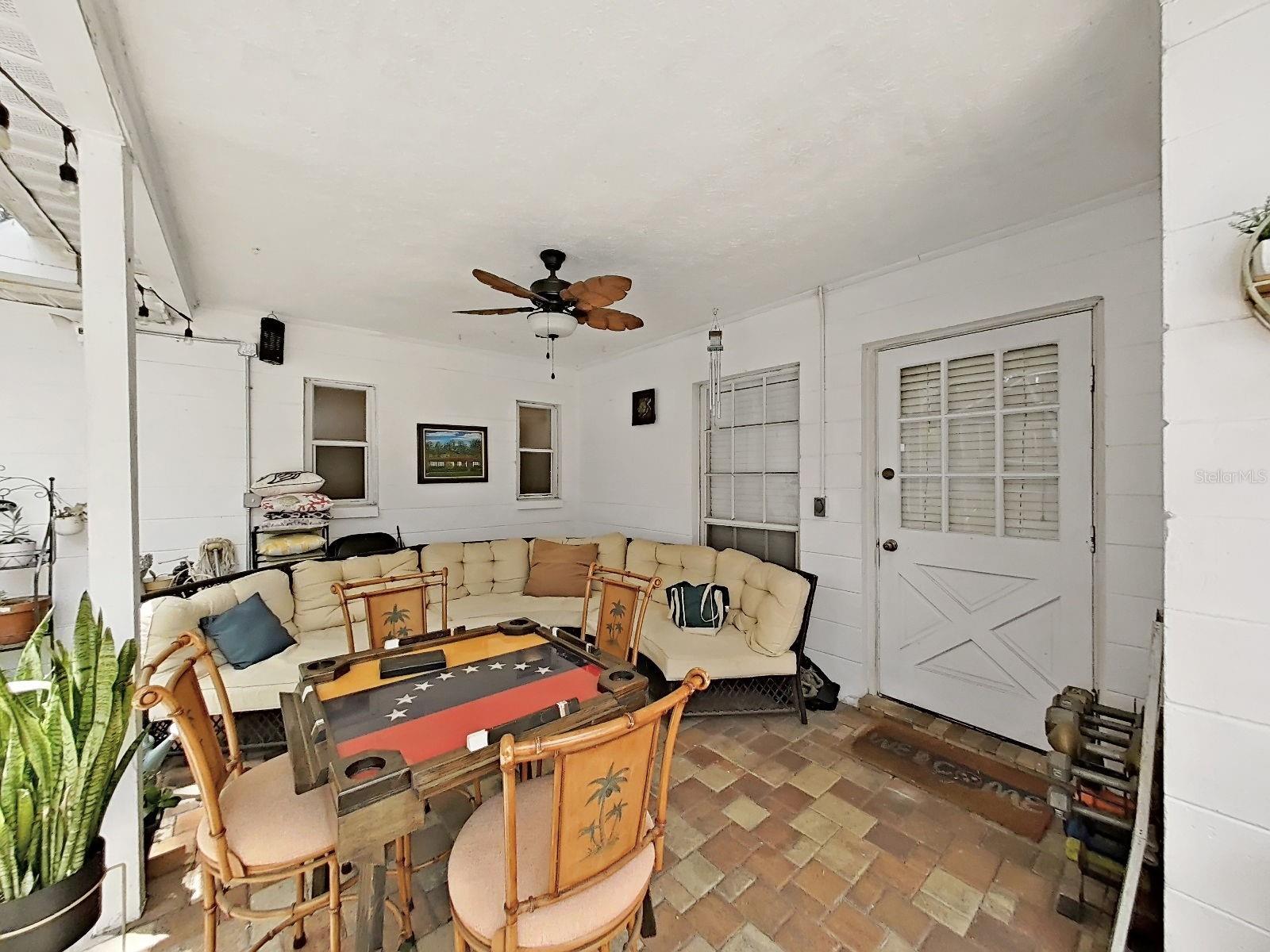 nice covered outdoor space overlooking the pool, rear door opens to fam rm/kitchen