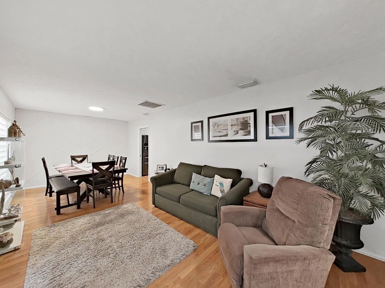another view of living and dining rooms, doorway to kitchen in the back right