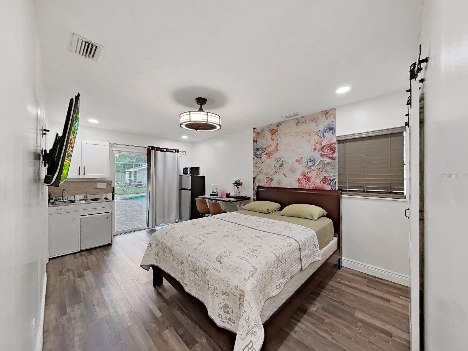 primary bedroom w walk-in closet, new sliding glass doors lead to pool area