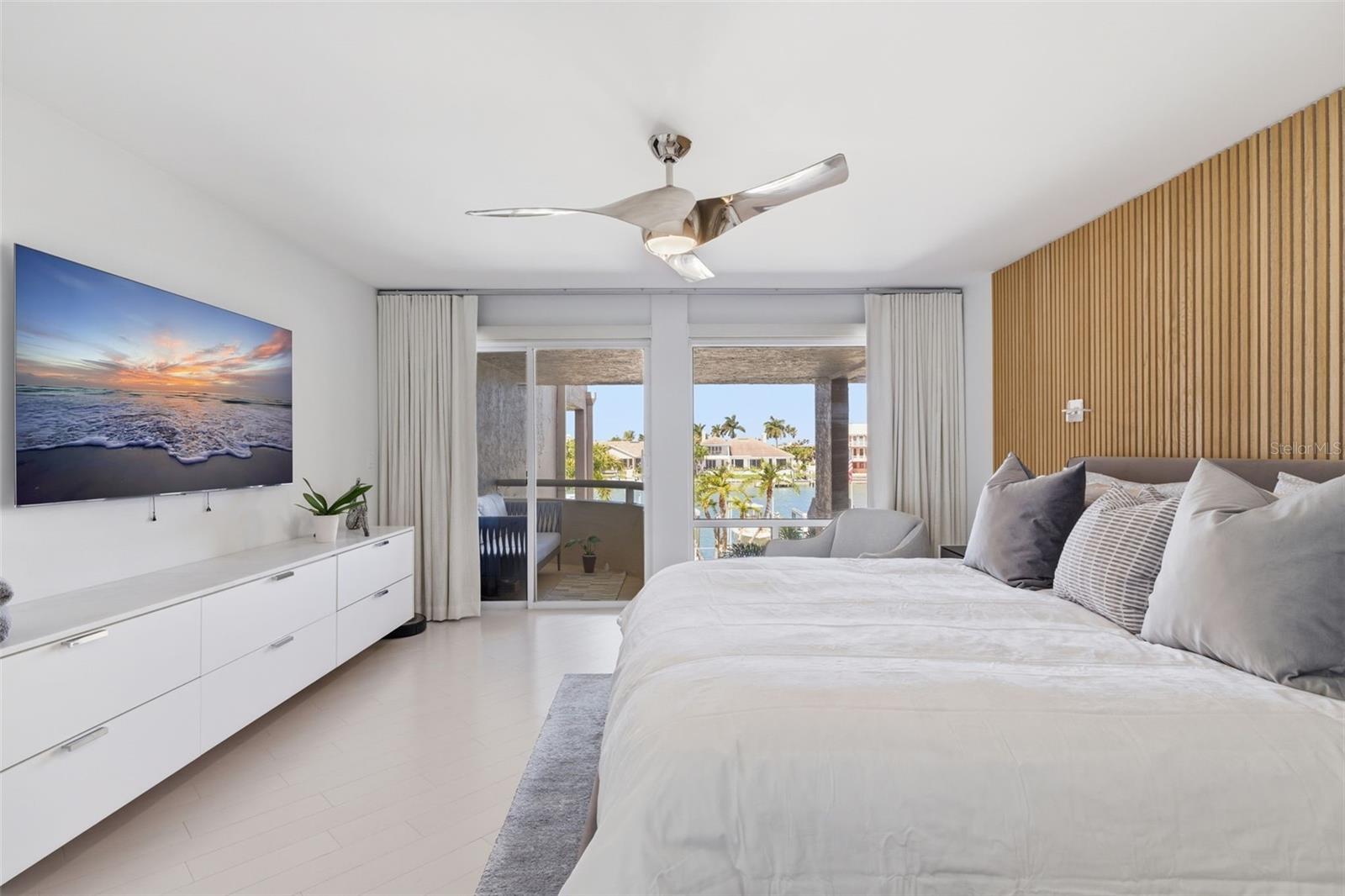 Spacious waterside primary suite also features remote controlled blinds.