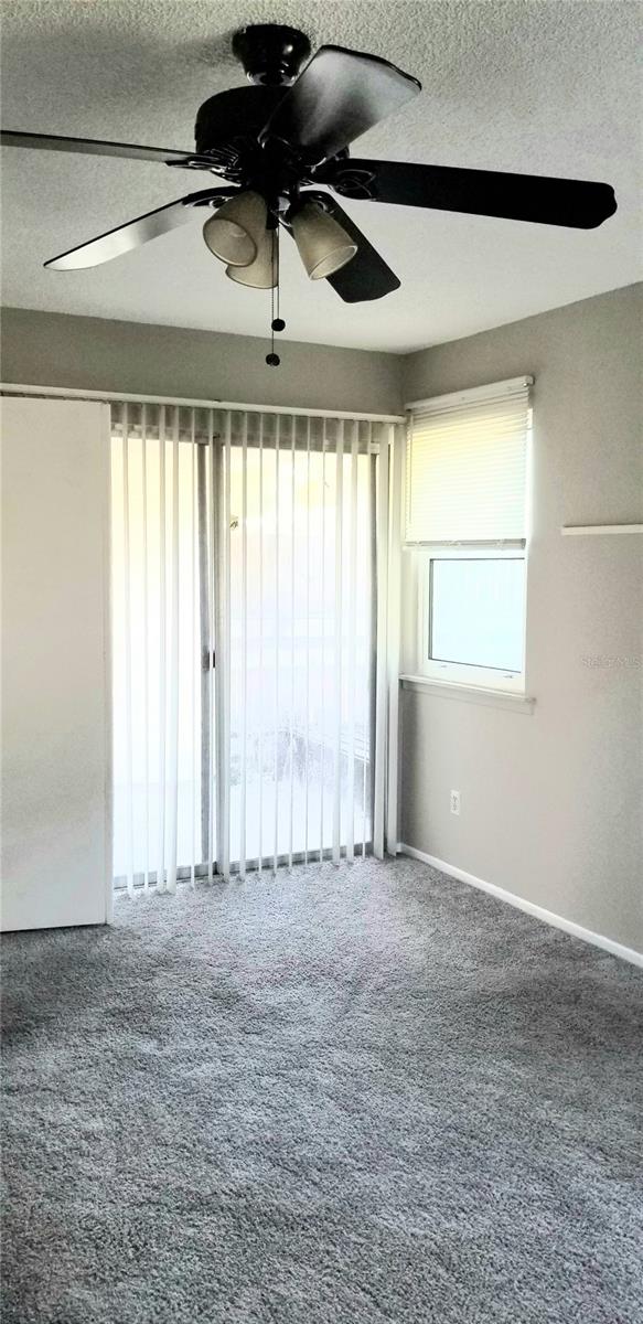 Master bedroom with glass sliding door leading to back covered porch