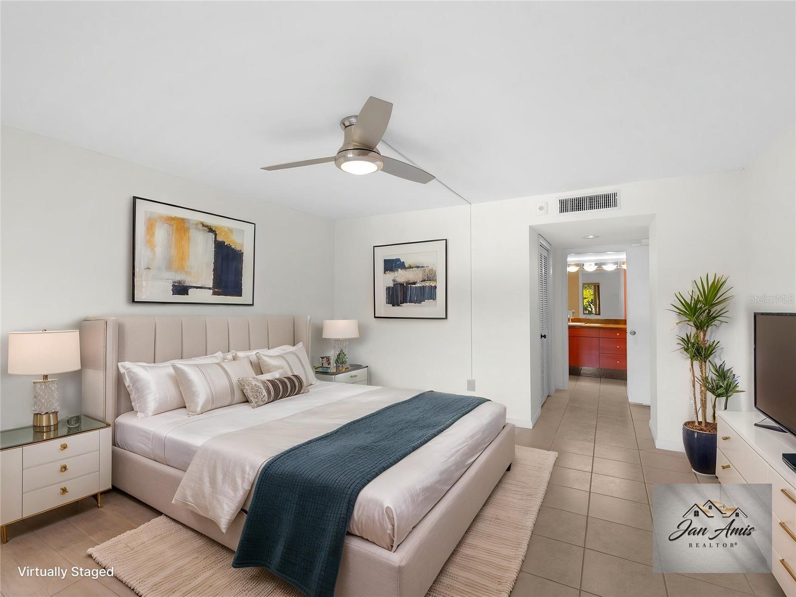 Staged primary bedroom looking toward ensuite bath