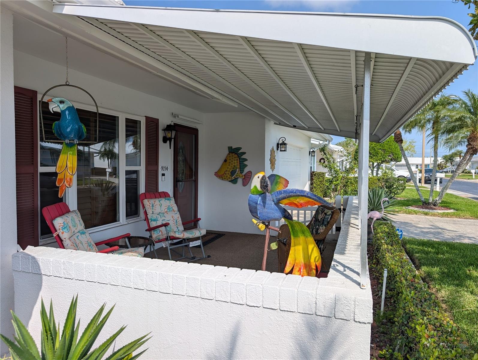 View of covered front porch with pebble tek flooring.  Great place to enjoy the Florida outdoor lifestyle. Main entry has new matching front & storm door including storm protection panels. COME ON IN... LET'S TAKE A TOUR!