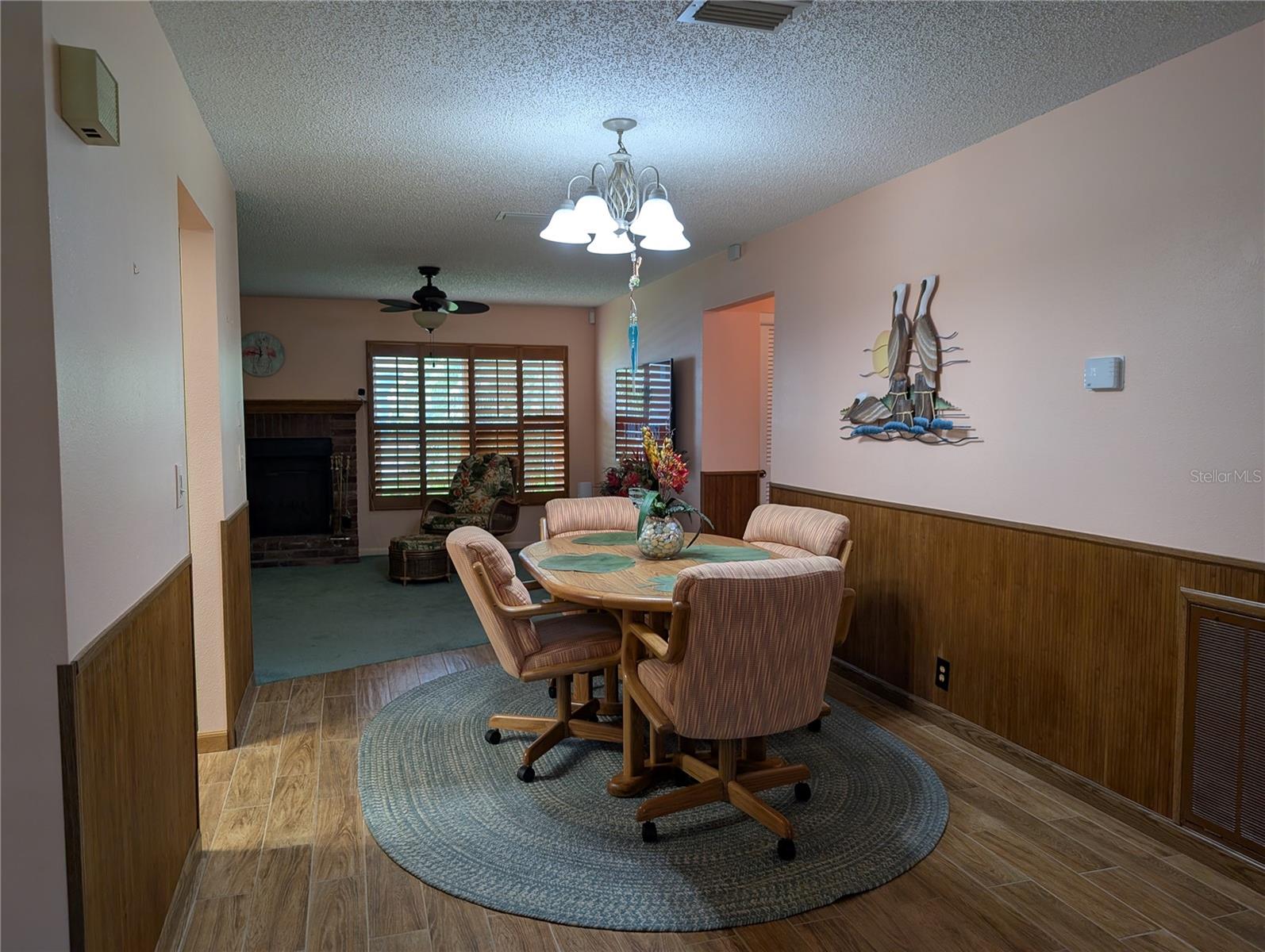 View from living room into dining room. Thermostat on right wall.  Kitchen is to the left.