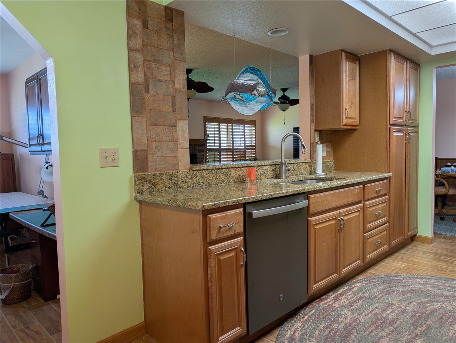 View from dinette area into Bonus room (left), Florida room (in pass thru window) and dining room at end of kitchen. Better view of gorgeous rustic tile backsplash.