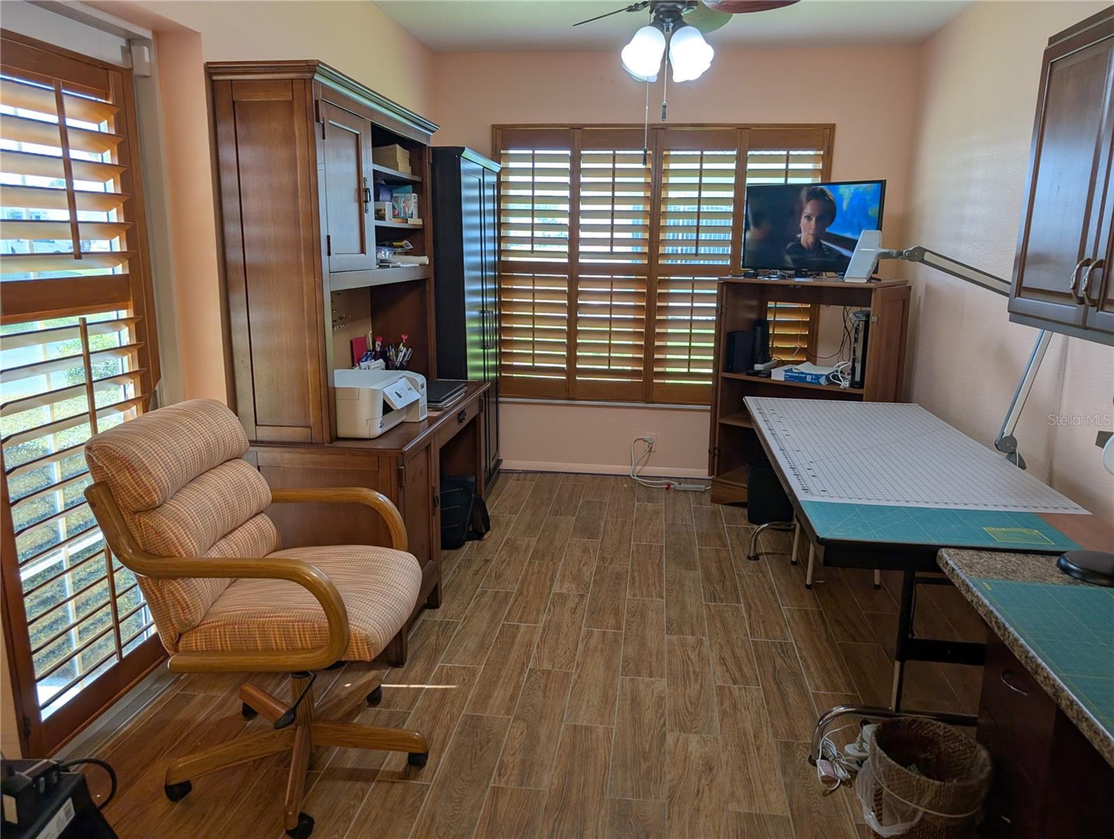 Bonus room is currently used as office and craft room.  Same decor is carried throughout the interior.  Side exterior door is lower left behind chair.