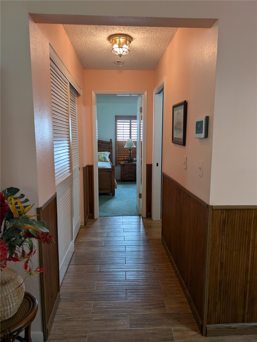 Hall closet on left, interior laundry with access to garage on right and primary bedroom straight ahead. Home is monitored by ADT security system on right wall.
