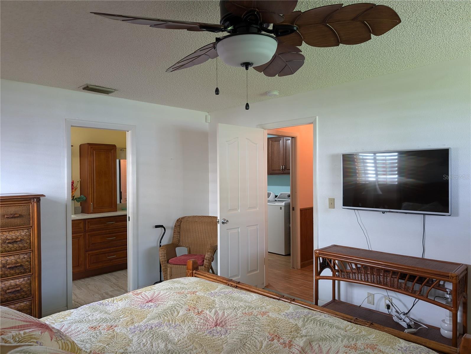 View thru primary bedroom to bathroom and hallway entry. Laundry visible to left of bedroom exit.