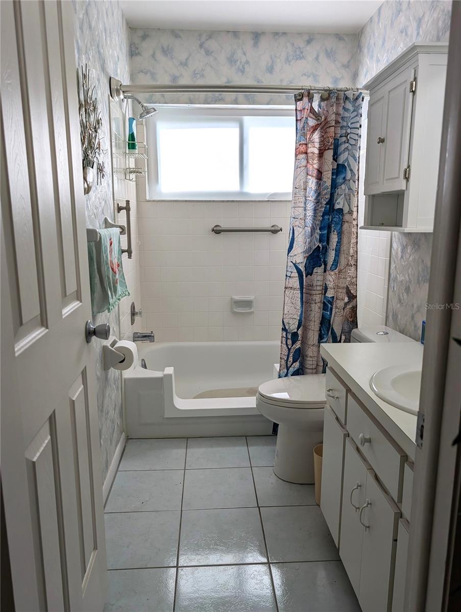 Tub has been converted into a walk-in shower for safer entry.  Grab bars installed for additional safety.