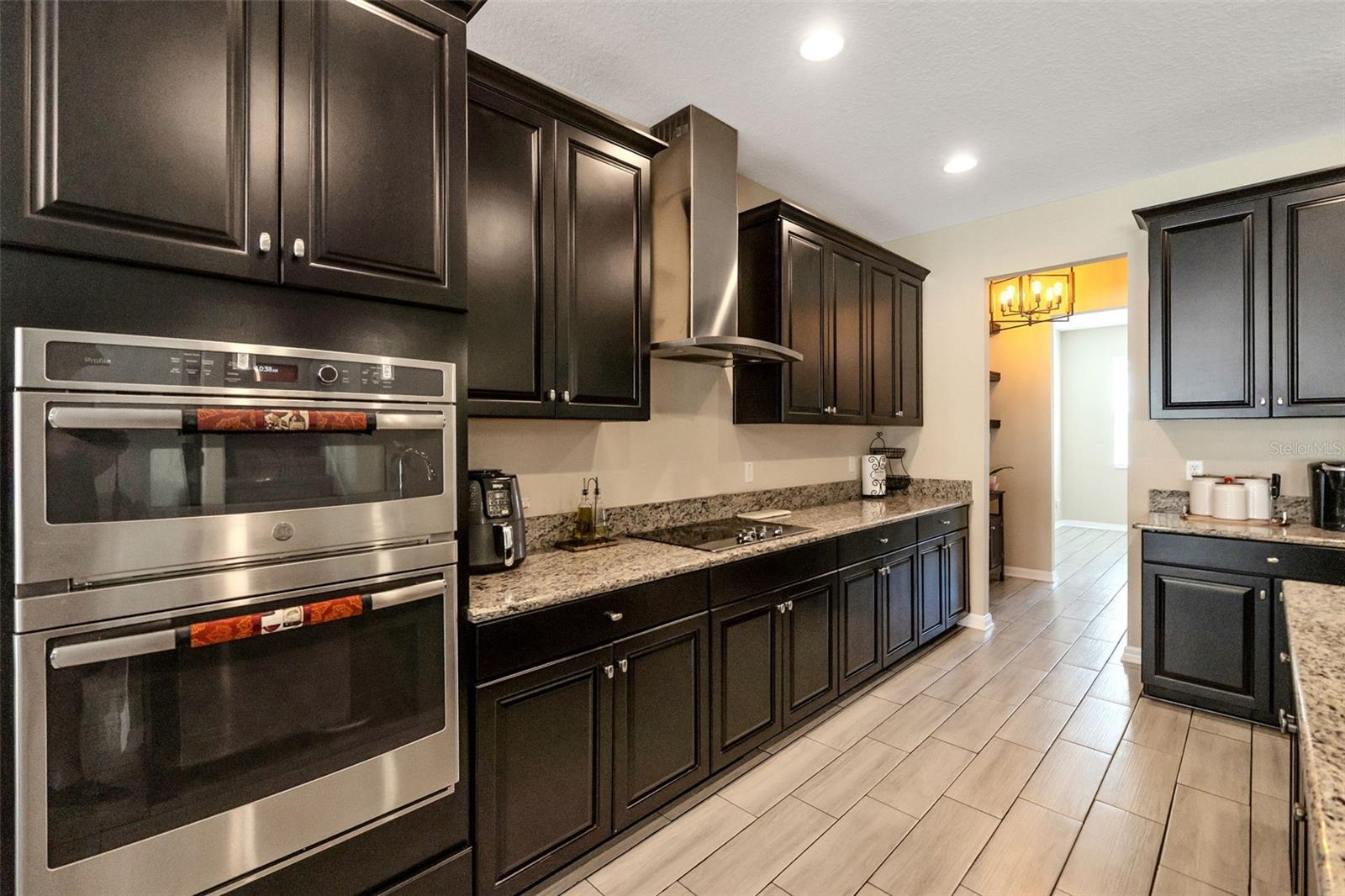 Kitchen with built-in appliances and range hood