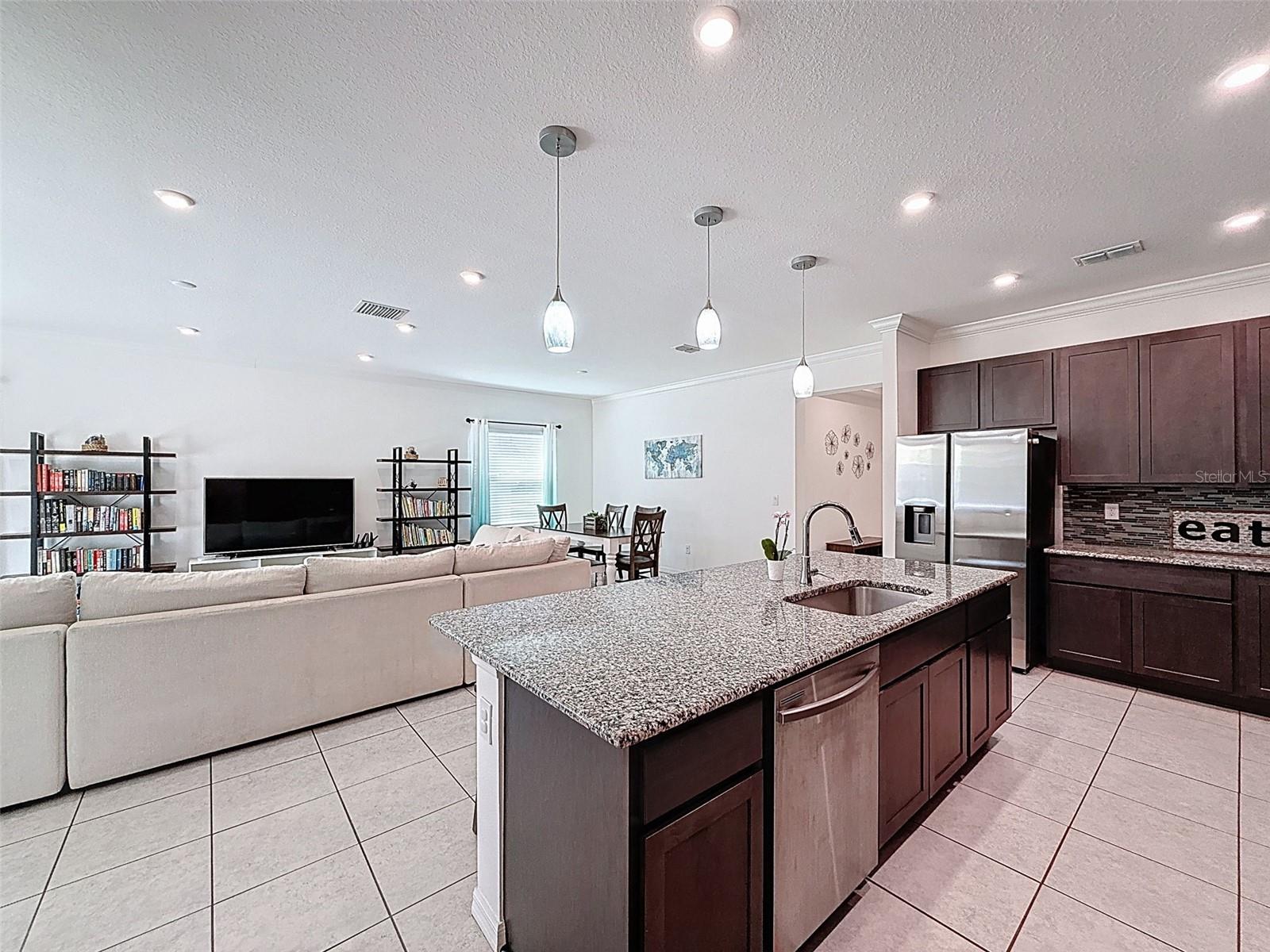 Stainless appliances with layered recessed and pendant lighting