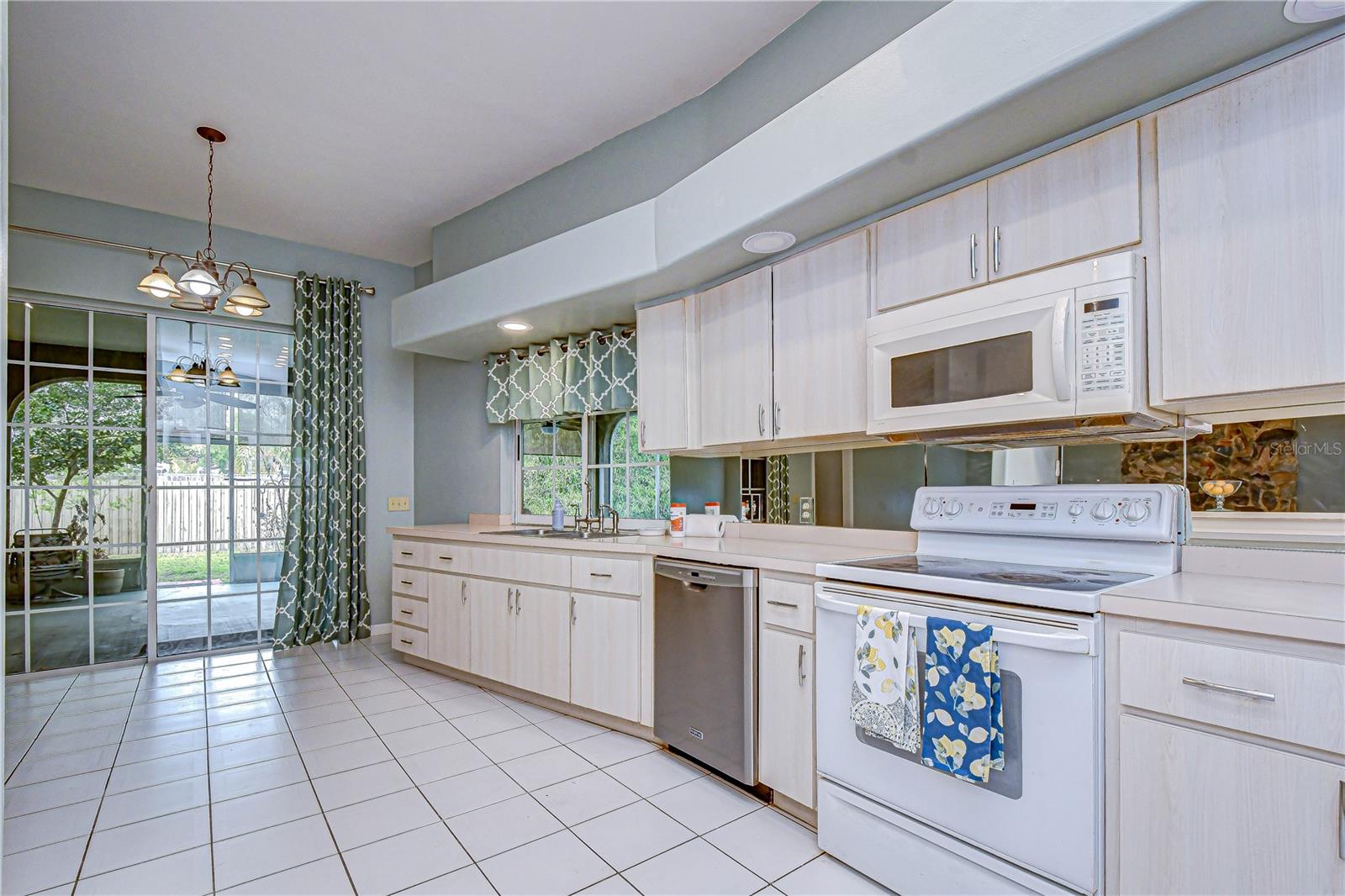 Sunlit kitchen with plenty of counter space, and sliding doors opening to the patio.