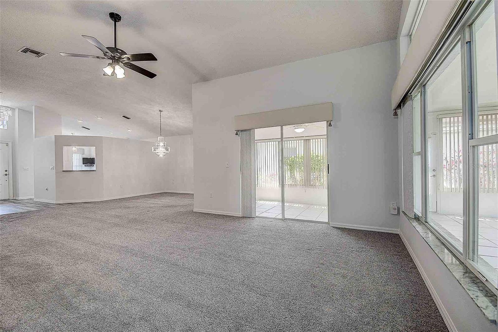 Great room with ceiling fan and convenient access to the enclosed Florida room.