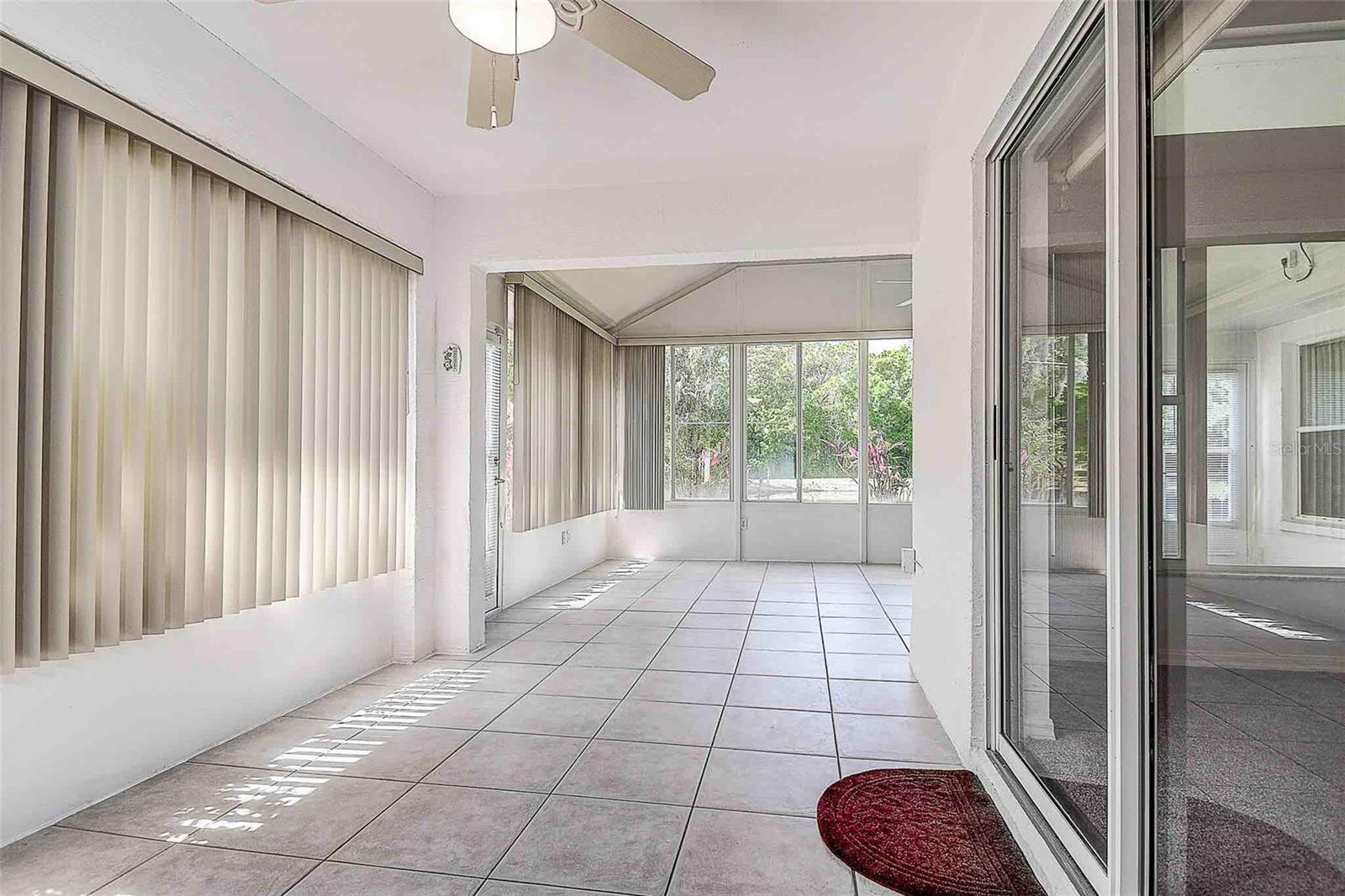 Covered and enclosed Florida room with ceramic tile, view from dining area.