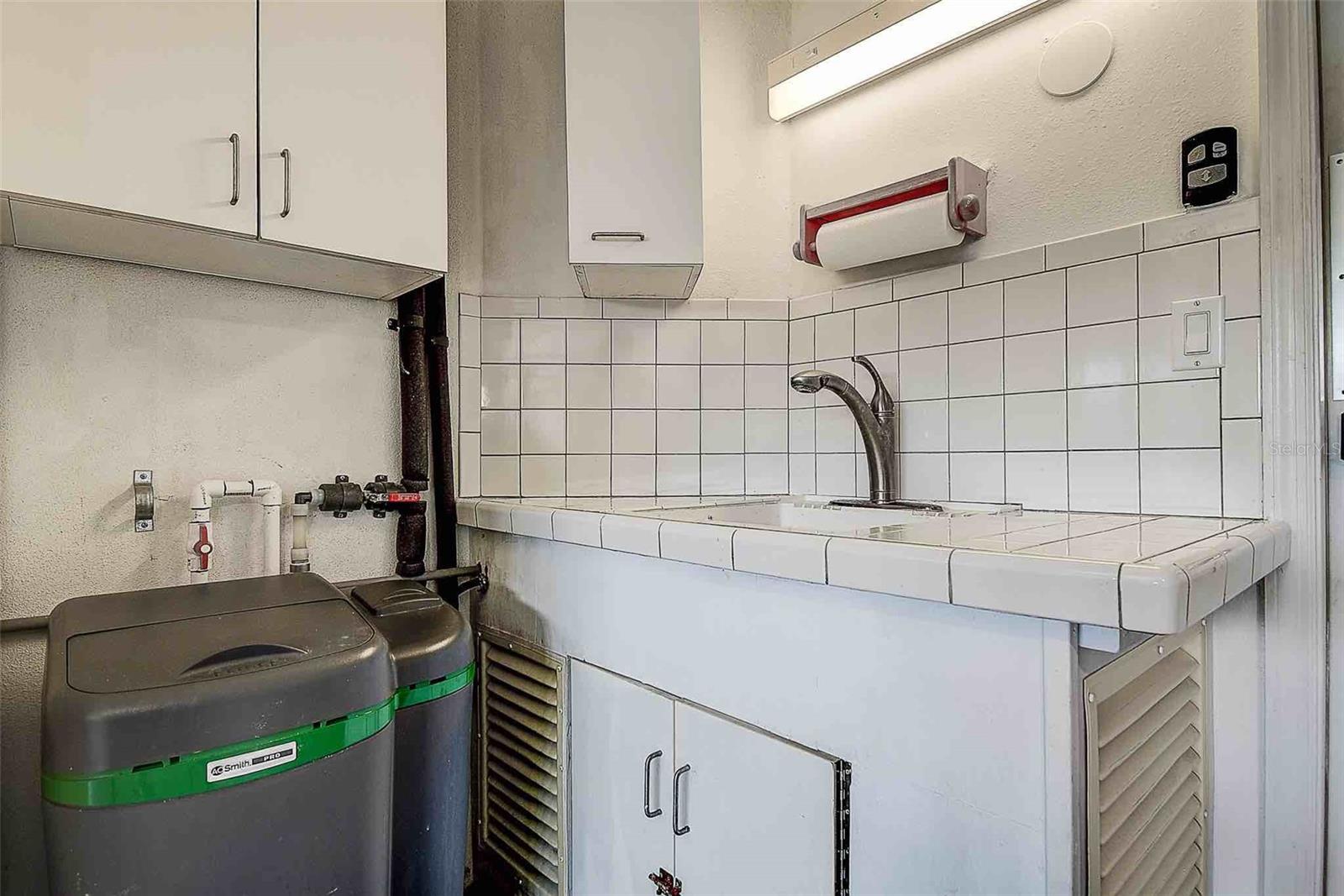 Inside garage utility sink with cabinetry and new A.O. Smith water softener (2024).
