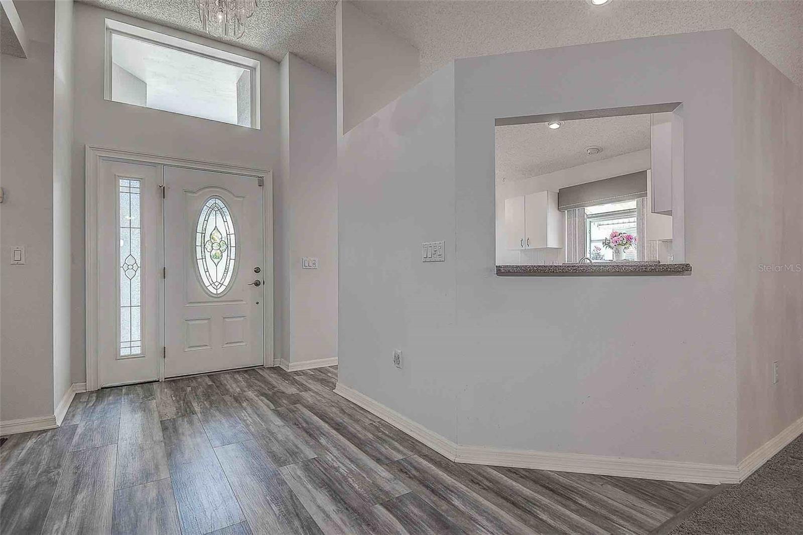 High vaulted ceilings at the foyer entry is inviting to welcome family and friends.