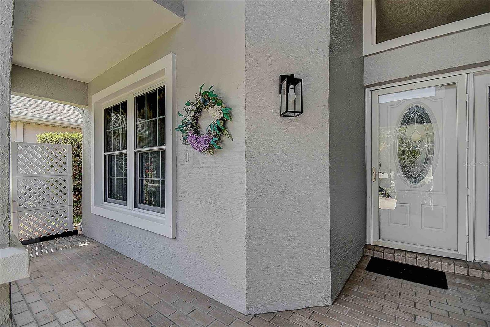 Beautiful entry with stamped pavers and covered front patio/porch.