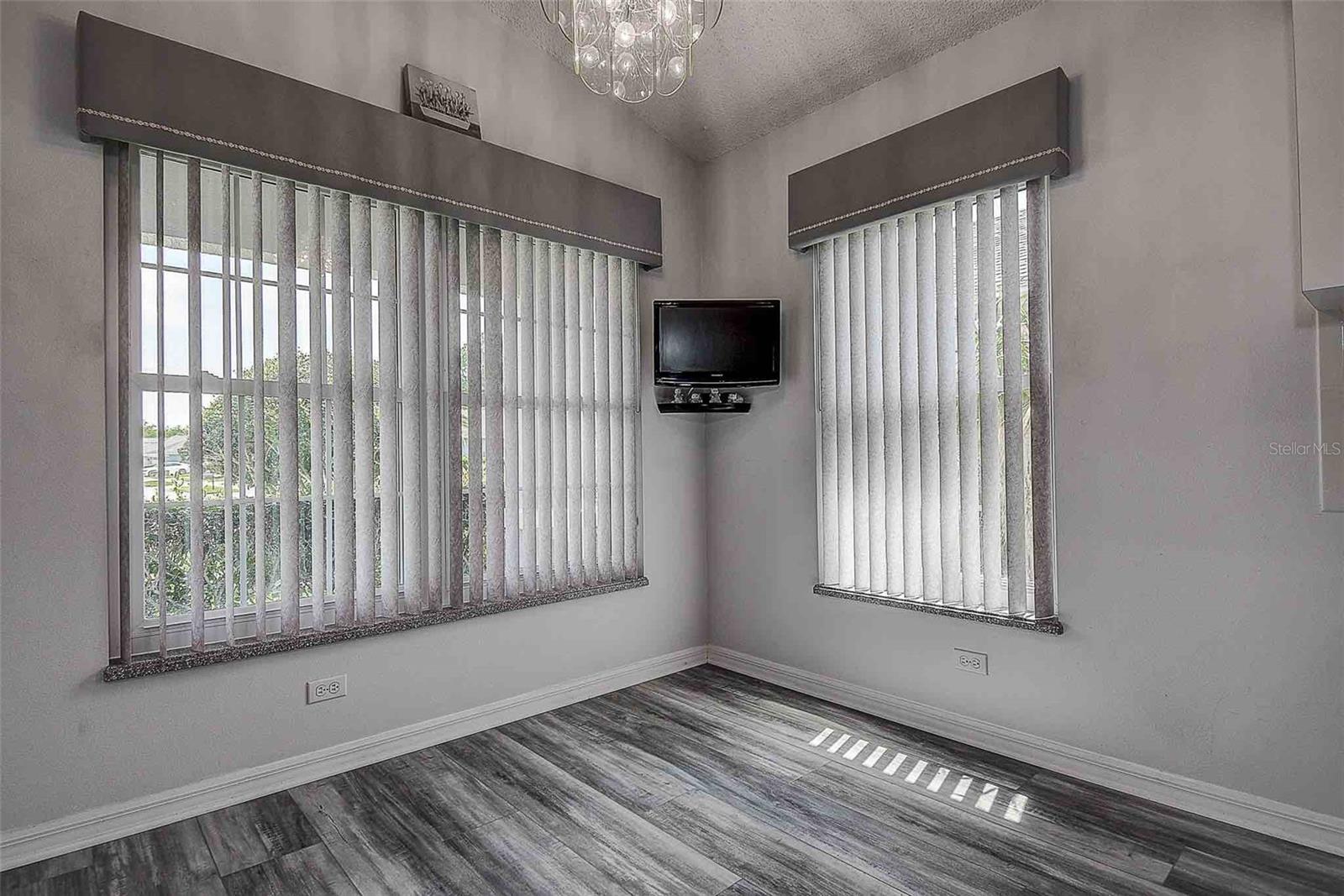 Kitchen eat in space / dinette with mounted TV and a corner pantry with built in shelving.