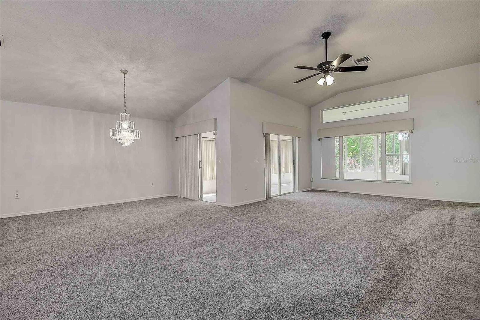 Great room with vaulted ceilings, and open to the dining room with chandelier.