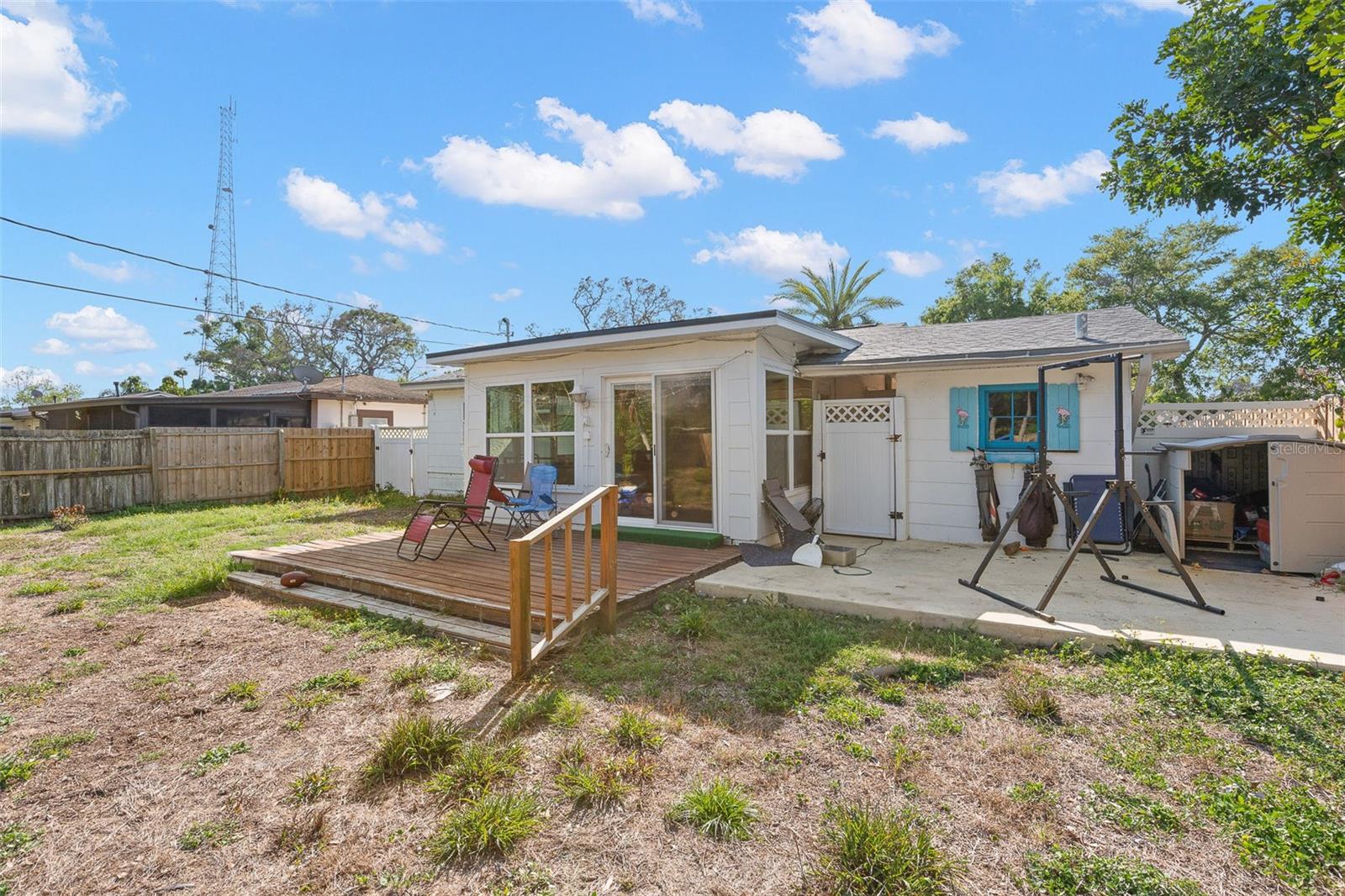 Spacious fenced backyard featuring a wood deck, open green space, and room to create your ideal outdoor living area, garden, or entertaining space.