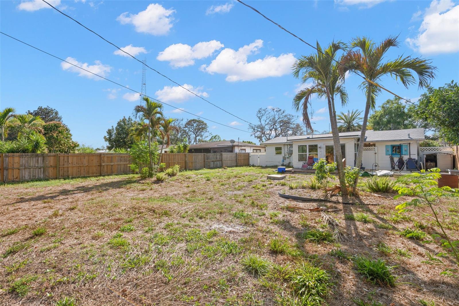 Large fenced backyard with deck and expansive open space, providing privacy and flexibility for a variety of outdoor uses.