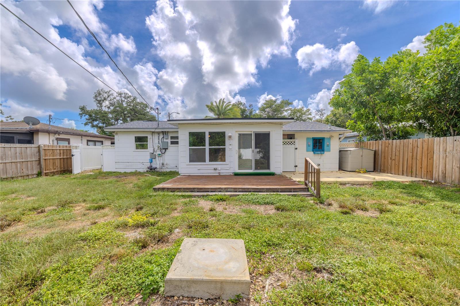 Generous fenced backyard with a wood deck and plenty of open space, offering endless potential for outdoor living, gardening, or entertaining.