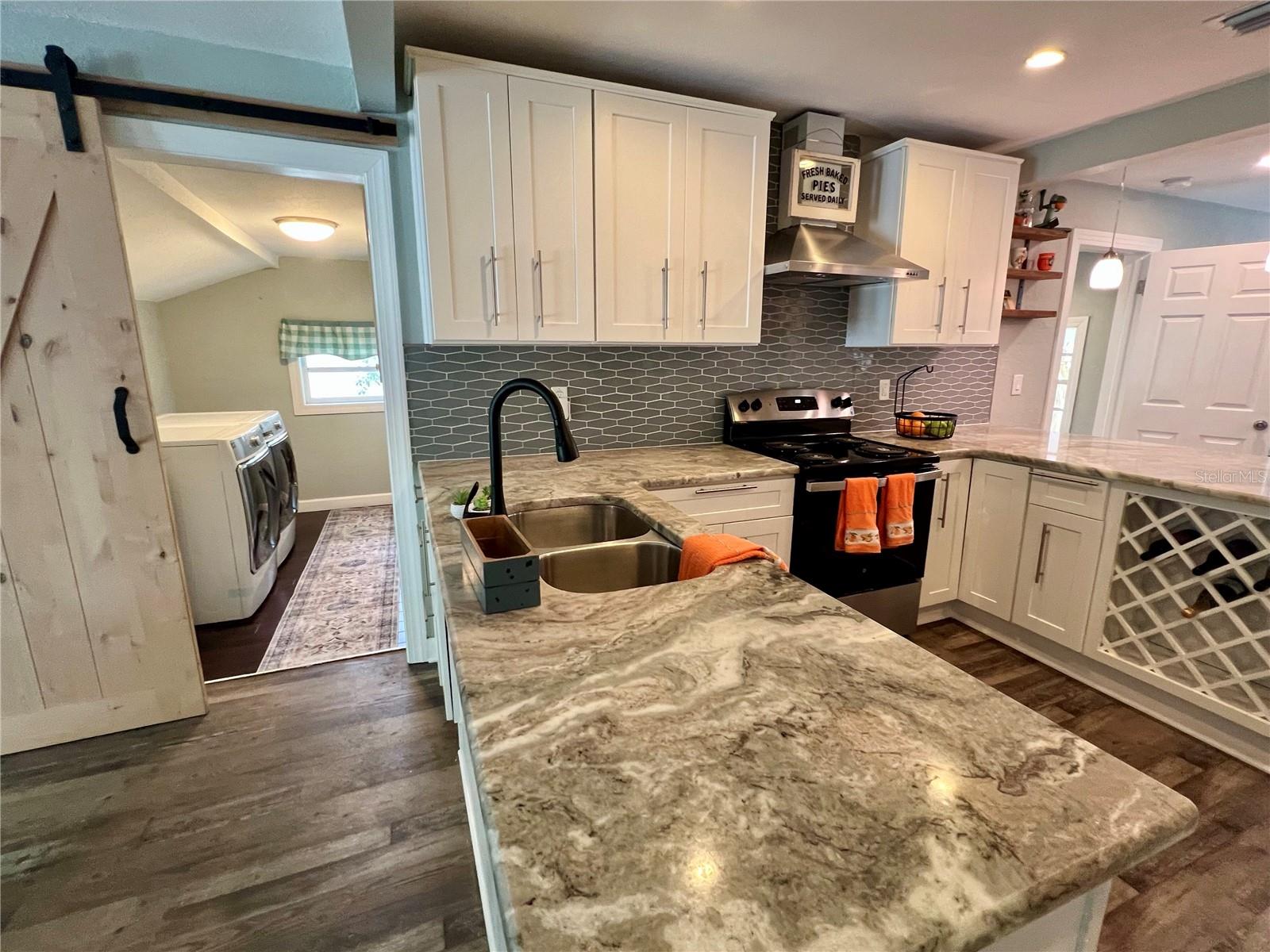 A separate laundry room, adjoining the kitchen, is tastefully stashed behind  a wooden barn door.