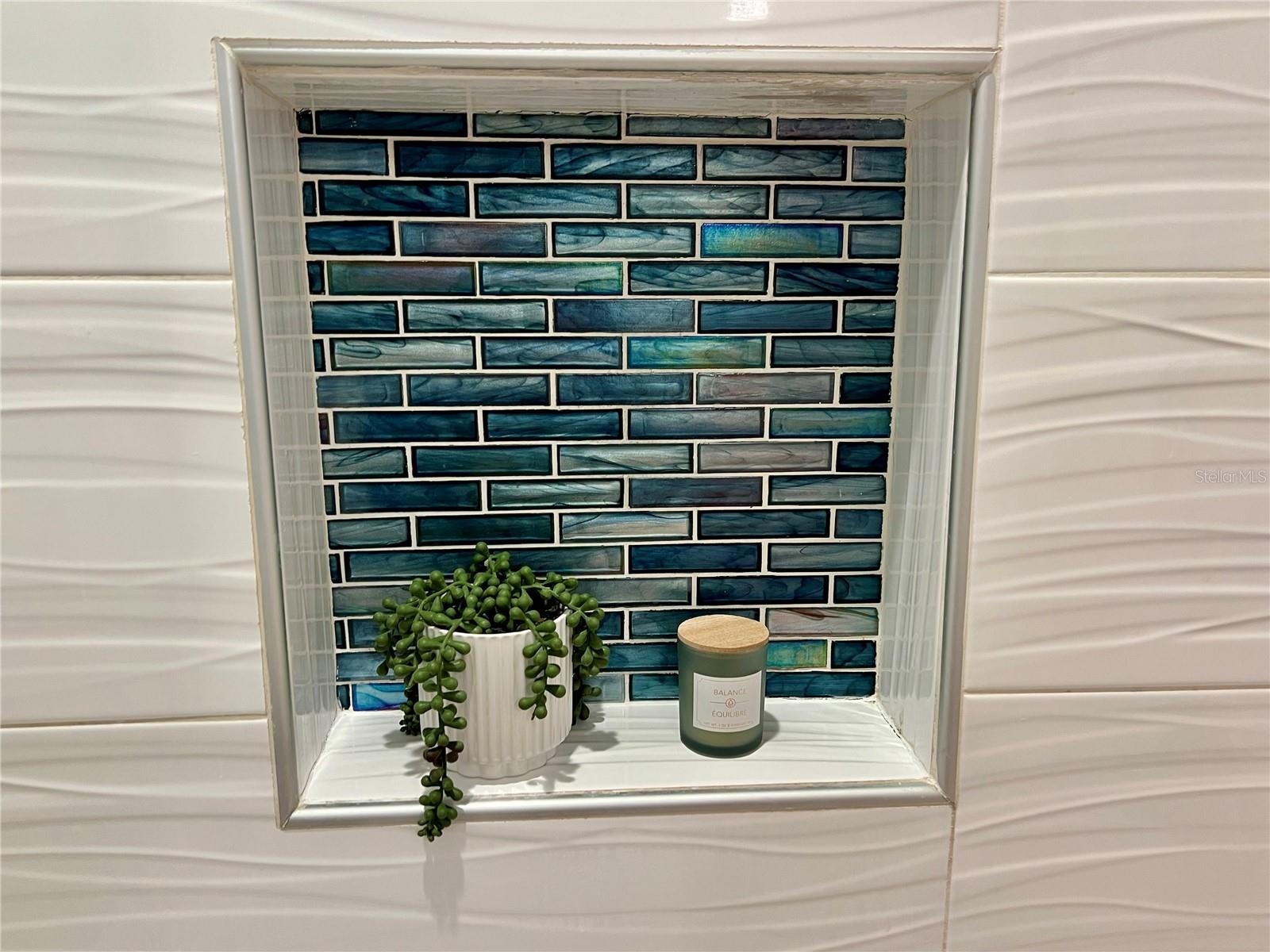 Iridescent, mermaid tile shines in the 2nd bathroom shower toiletries nook