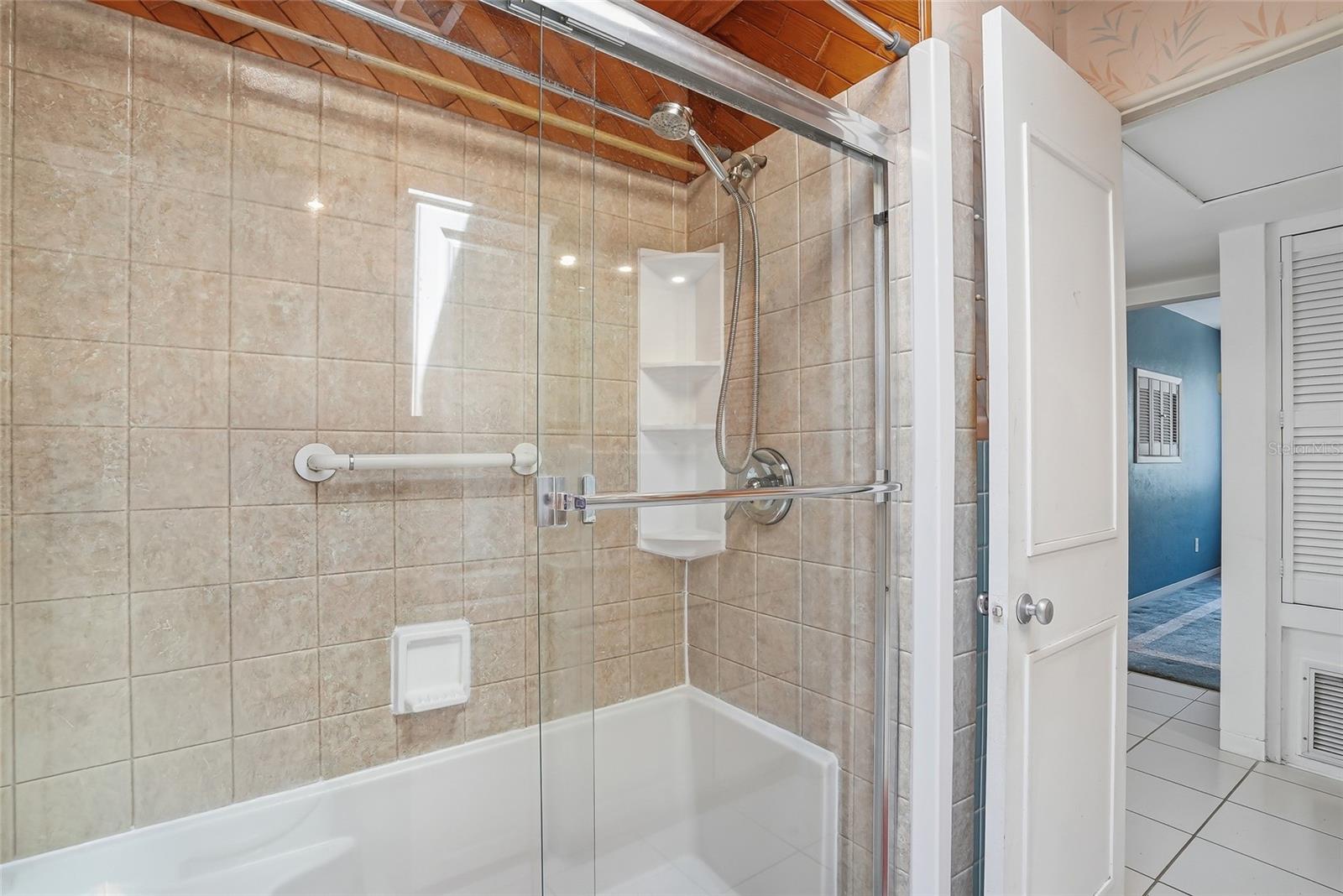 Walk-in shower with elegant glass doors.