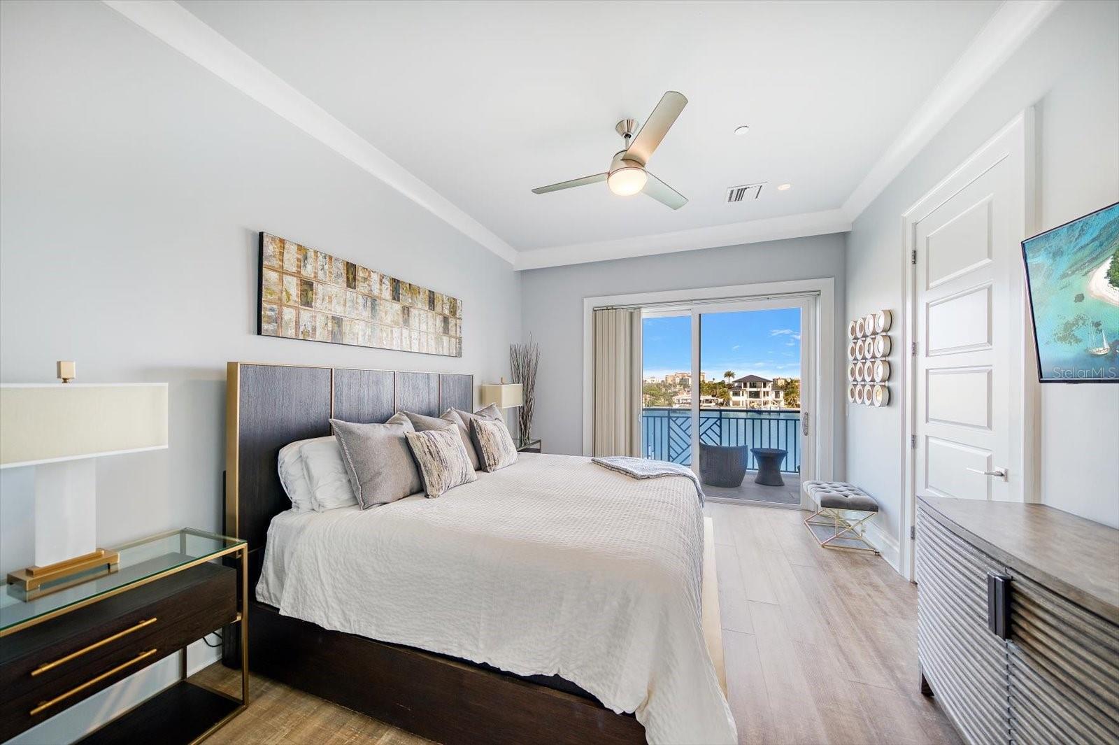 Upstairs, the third floor offers an inviting primary suite with a private balcony overlooking the water, a spacious ensuite bath with dual sinks, water closet, and walk-in closet.