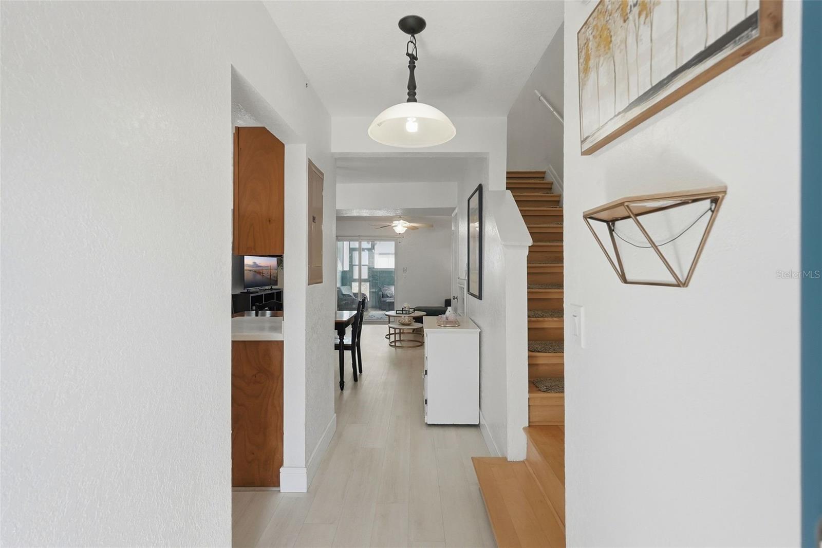 Entry with hardwood stairs on the right and the kitchen on the left