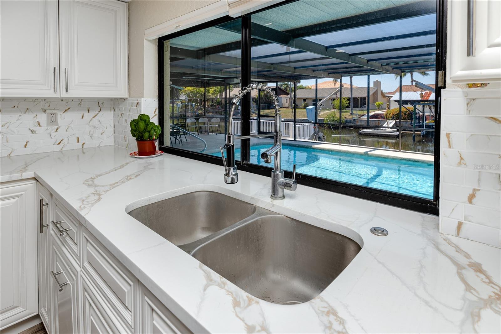 Kitchen sink with pool/canal view at 9903 San Mateo Way, Port Richey, FL 34668