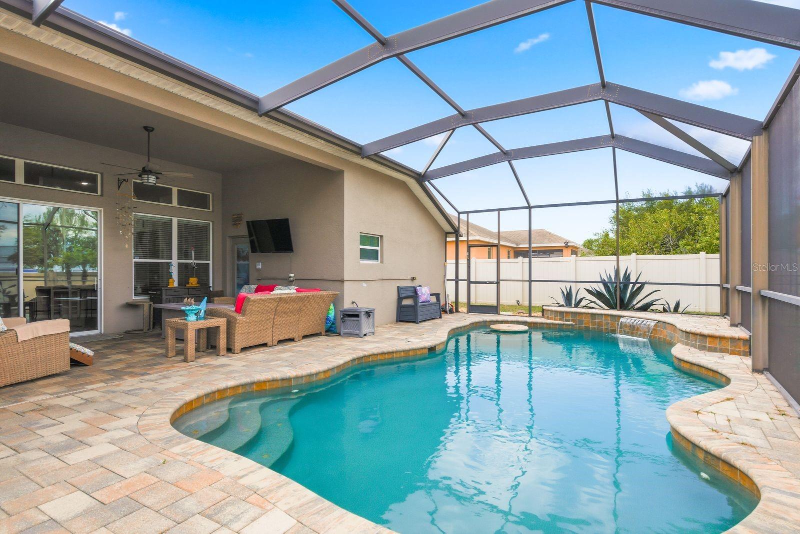 Custom Heated Saltwater Pool with Pavers, Waterfall, Built in Table and Seating