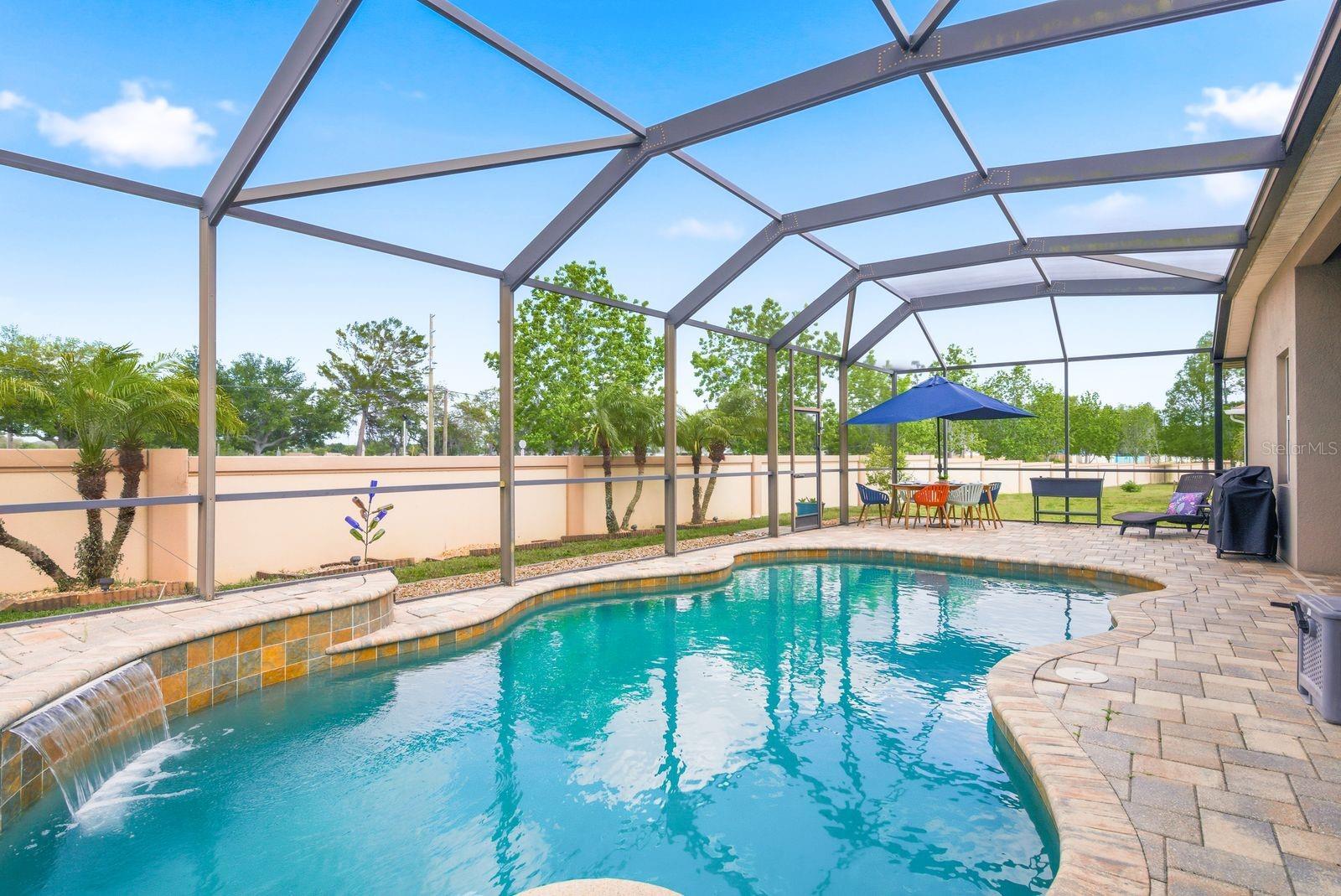 Custom Heated Saltwater Pool with Pavers, Waterfall, Built in Table and Seating