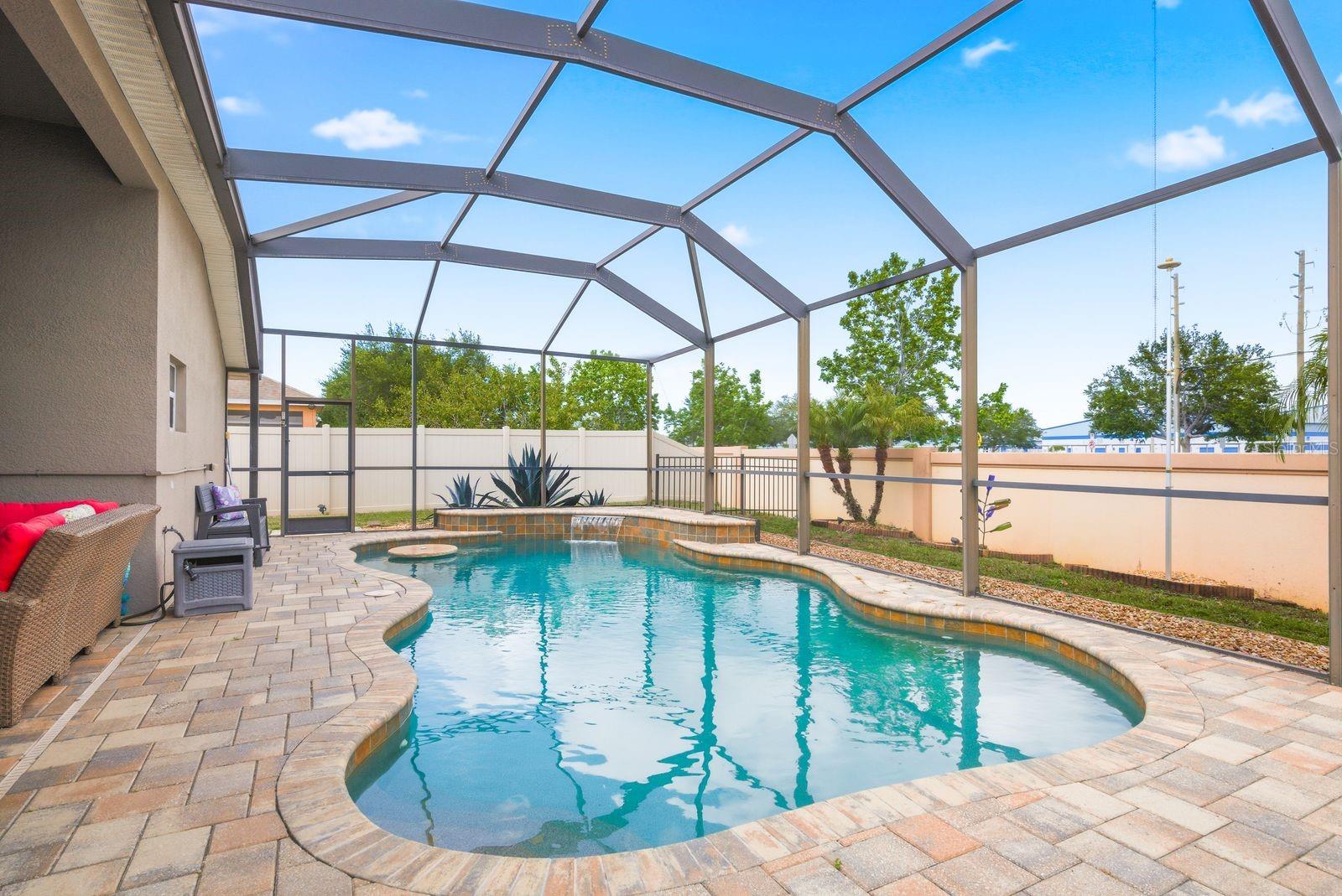 Custom Heated Saltwater Pool with Pavers, Waterfall, Built in Table and Seating