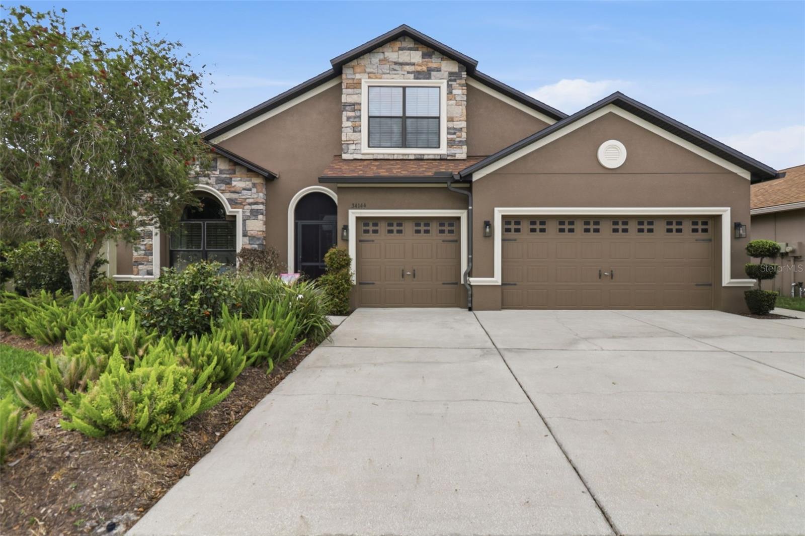 Beautifully maintained home with exceptional curb appeal, featuring stone accents, mature landscaping, and a spacious three-car garage. Welcoming front entry with arched details sets the tone for this thoughtfully designed residence.