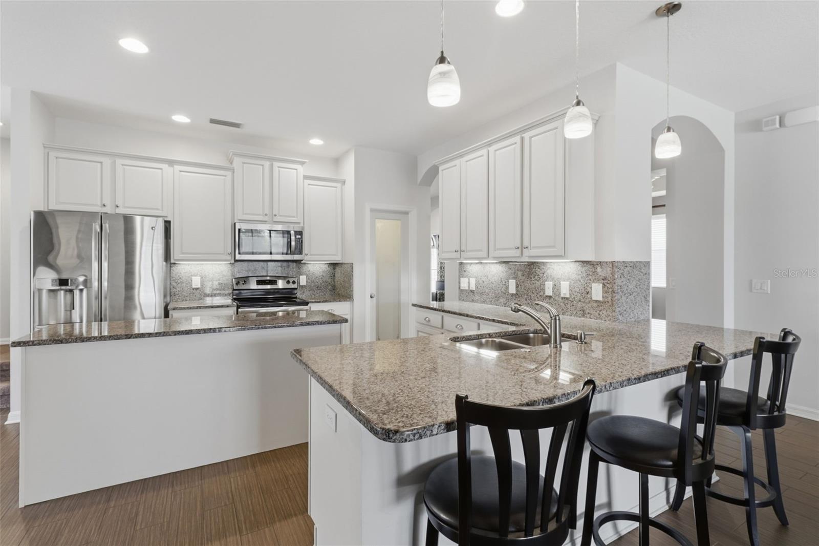 Additional view of the spacious kitchen highlighting the large center island, granite countertops, and open layout ideal for cooking and entertaining.