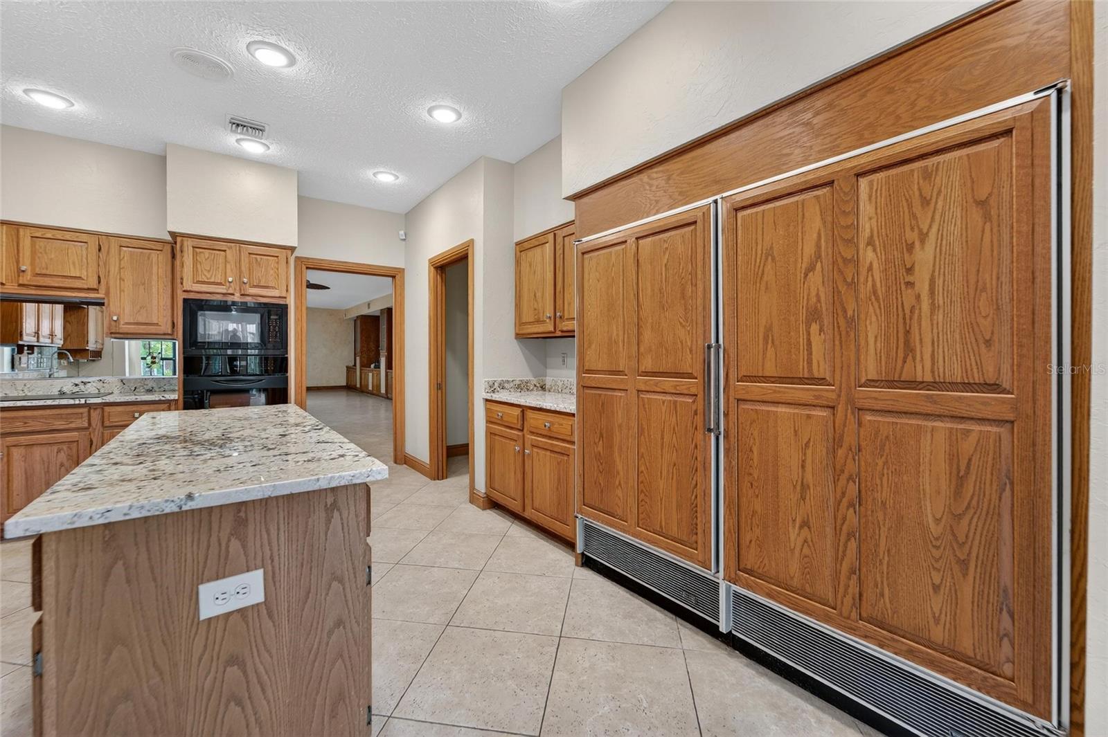 Wood cabinetry adorning the oversized Refrigerator/Freezer