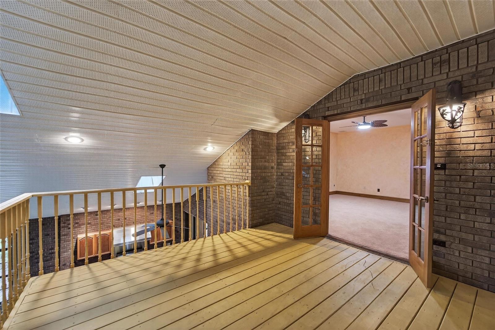 Balcony overlooking indoor pool from primary bedroom
