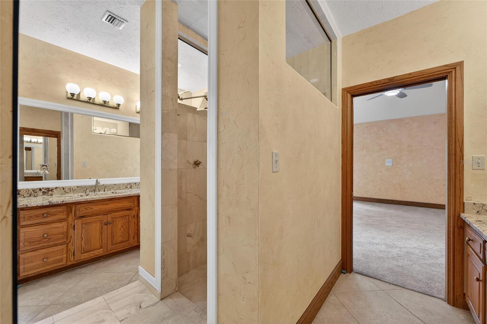 Dual sink vanity with granite counters and wood cabinetry
