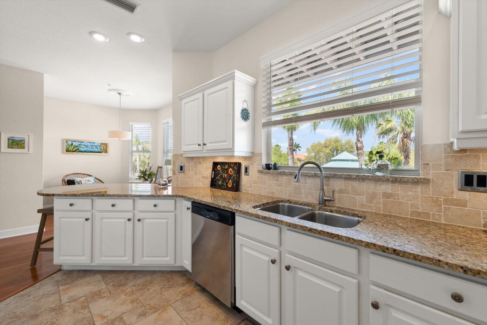 Bathed in natural light, this airy kitchen features crisp white cabinetry and expansive counters designed for the modern home chef.