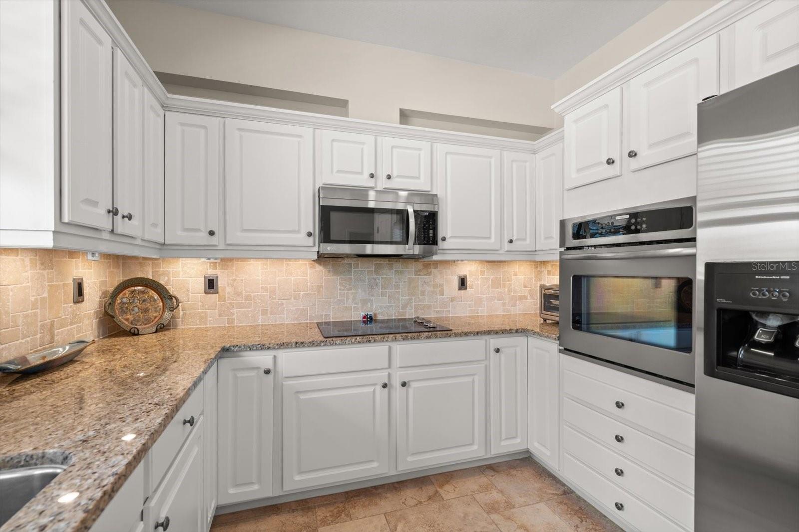 Built-in oven, glass cooktop, and vented exhaust fan/microwave provide all the modern conveniences a chef could desire.