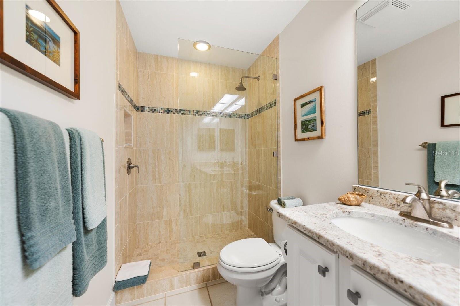 Guest bathroom with glass shower doors and easy walk-in shower.