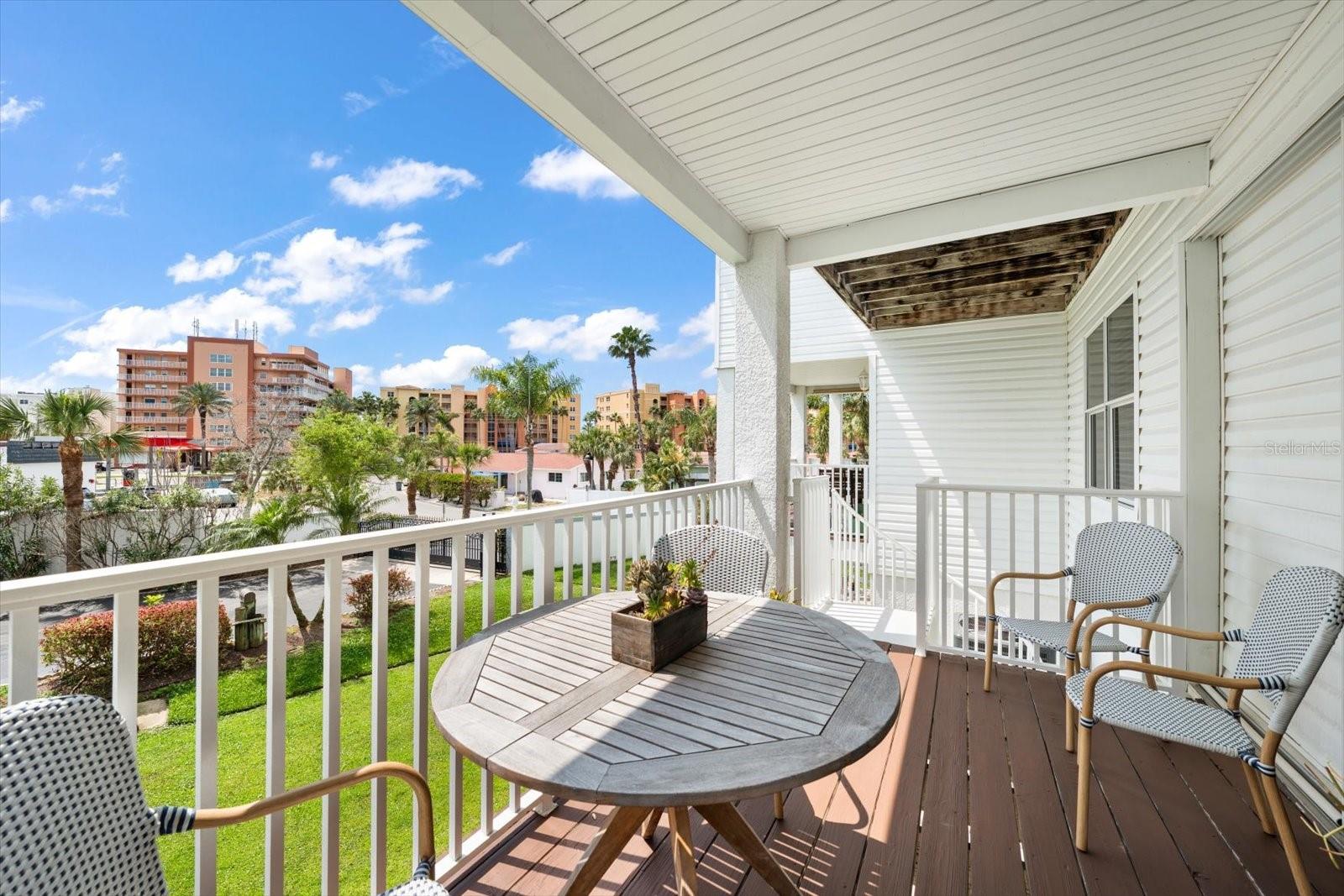 Sun lit terrace accessed from the great room, with a spiral staircase, leading to the ground level patio and common area grounds, which lead to the community swimming pool and spa.