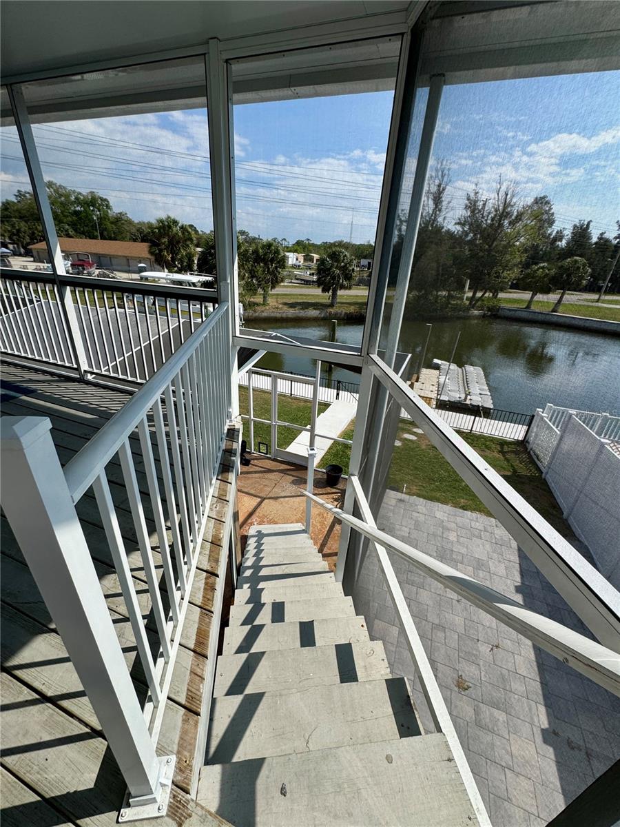 STAIRS LEADING DOWN TO THE LOWER LEVEL SCREENED IN LANAI
