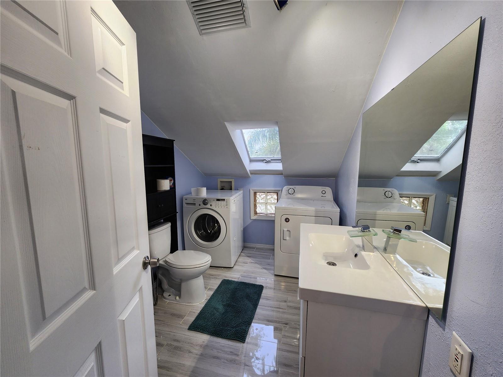 Apt bathroom with washer and dryer