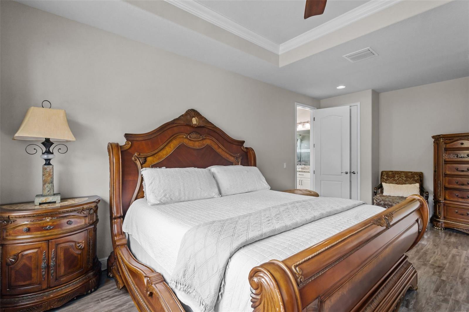 Spacious primary suite with tray ceiling and peaceful conservation views.