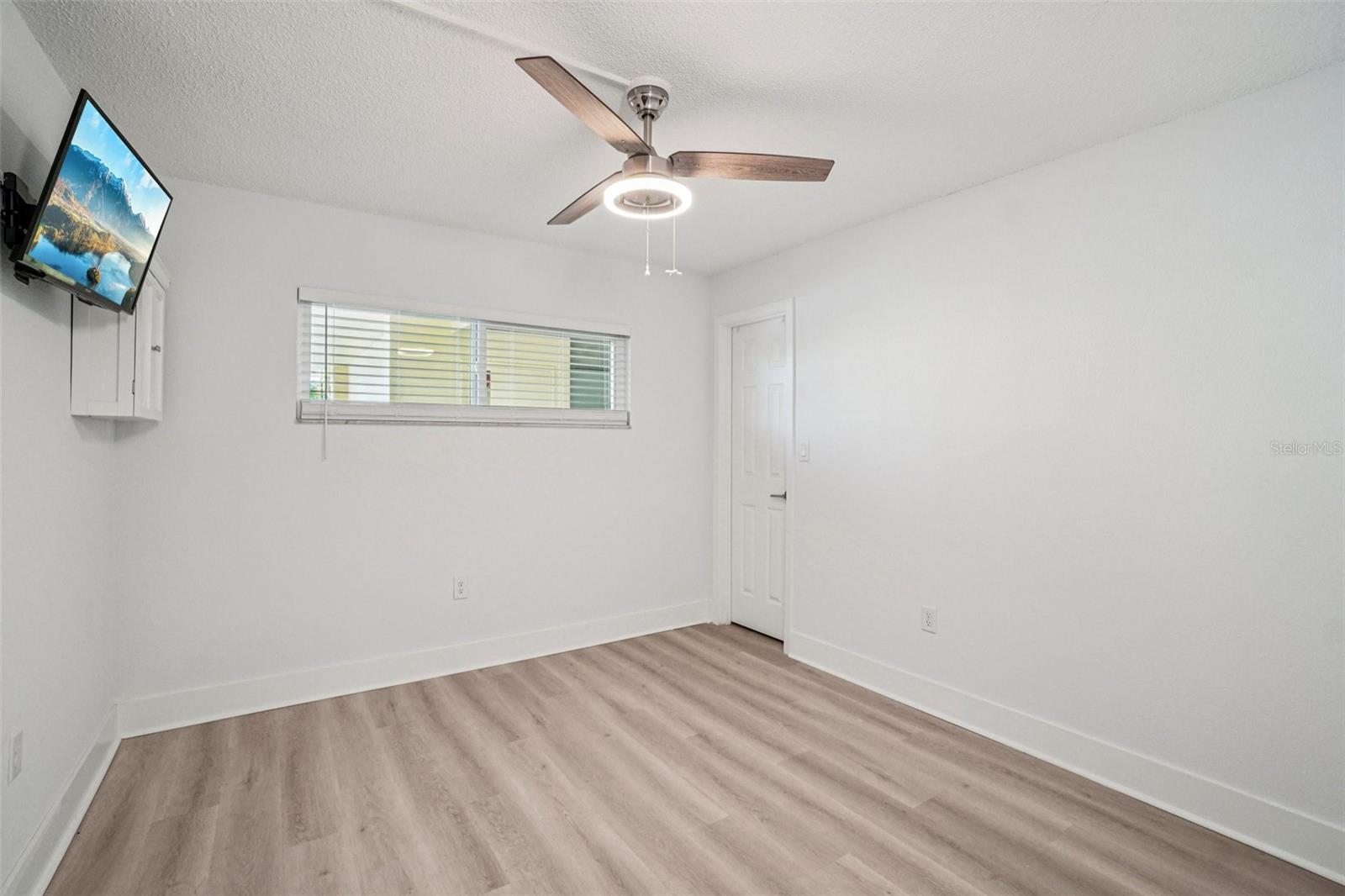 Bedroom #2 - This bright and airy second bedroom features light luxury vinyl plank flooring, a modern ceiling fan, a natural light-filled window, and a clean, neutral palette — a versatile space ready to serve as a guest room, home office, or personal retreat.