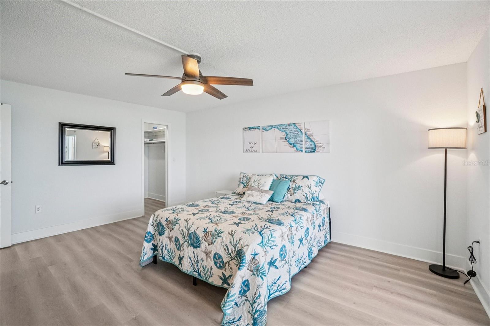Primary Bedroom (Alternate View) – A wider view of the primary suite reveals its impressive size, with open sightlines to the sparkling water beyond, a dedicated en suite bath entrance, and a clean, bright finish that perfectly captures the Florida waterfront lifestyle.