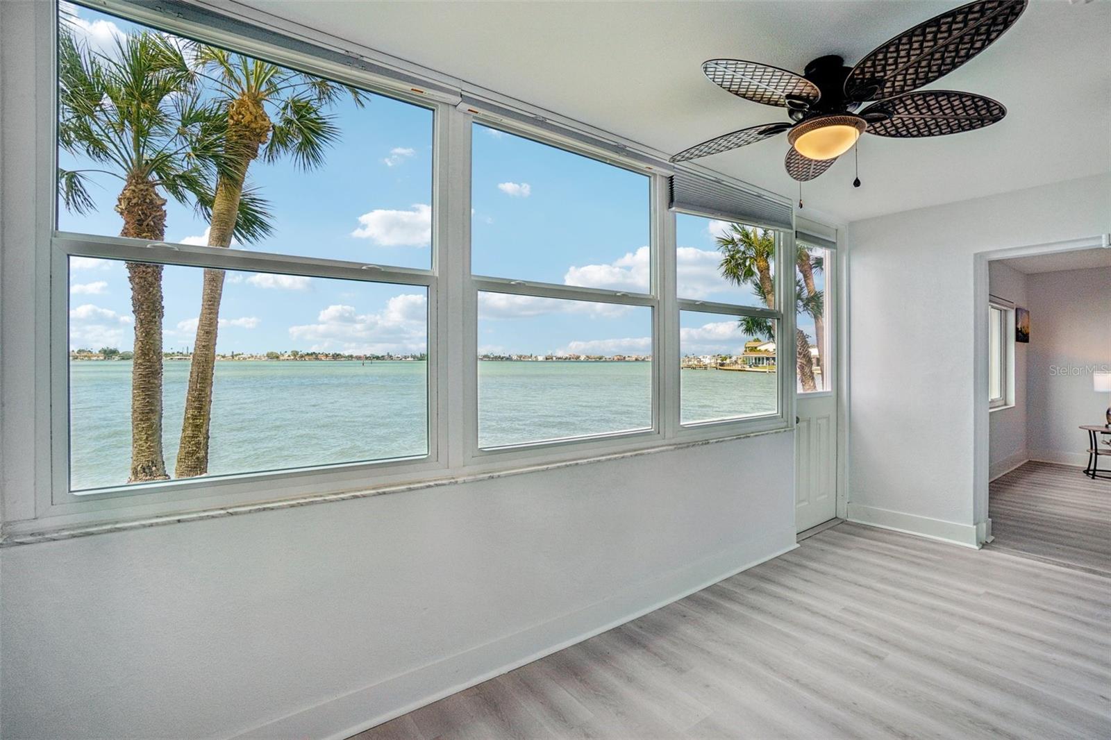 Florida Room Water View – A breathtaking wall of windows in the Florida room delivers sweeping, unobstructed views of the shimmering waterway and palm-lined shoreline — an extraordinary and rare feature that transforms everyday living into a perpetual waterfront escape.